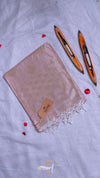 Beige scarf with white fringe on a light gray background with two pens.