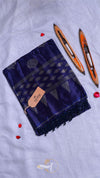 Blue fabric with a woven pattern and a brown tag on a gray background