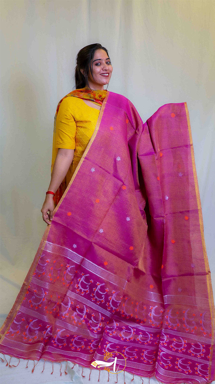 Woman wearing a pink saree with a yellow blouse against a plain background