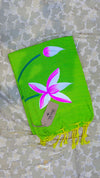 Green scarf with a pink flower design on a textured surface