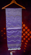Purple fabric with zigzag pattern on a hanger against a dark background