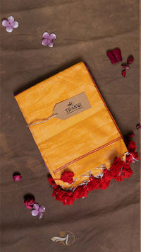 Yellow fabric package with a brand label on a brown background with flowers.
