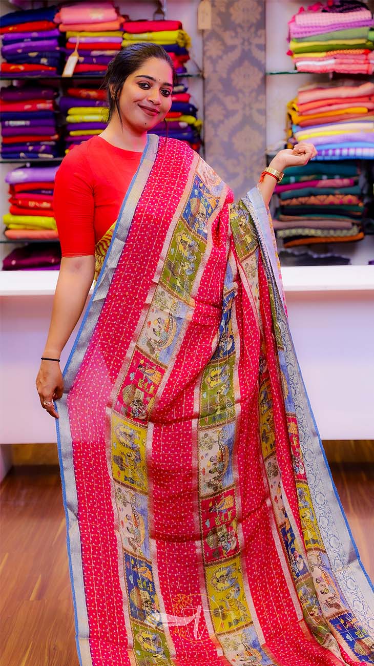 Woman wearing a colorful saree with a background of fabric stacks