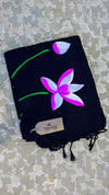 Black scarf with a pink and white lotus design on a textured surface