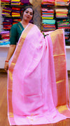 Woman holding a pink saree with a colorful background of folded fabrics