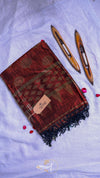 Red patterned scarf with black tassels on a white background
