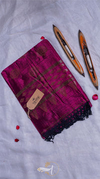 Magenta scarf with black patterns and a brand tag, accompanied by three wooden sticks on a light gray background.