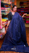 Woman holding a navy blue saree in a fabric store