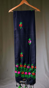 Black scarf with floral embroidery on a wooden hanger against a plain background