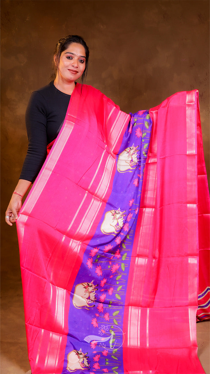 Woman holding a pink and blue saree with a brown background