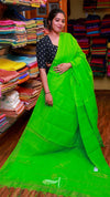 Woman wearing a bright green saree in a fabric store