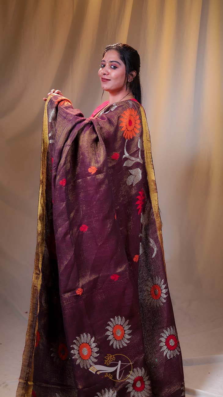 Woman wearing a traditional embroidered outfit against a plain background