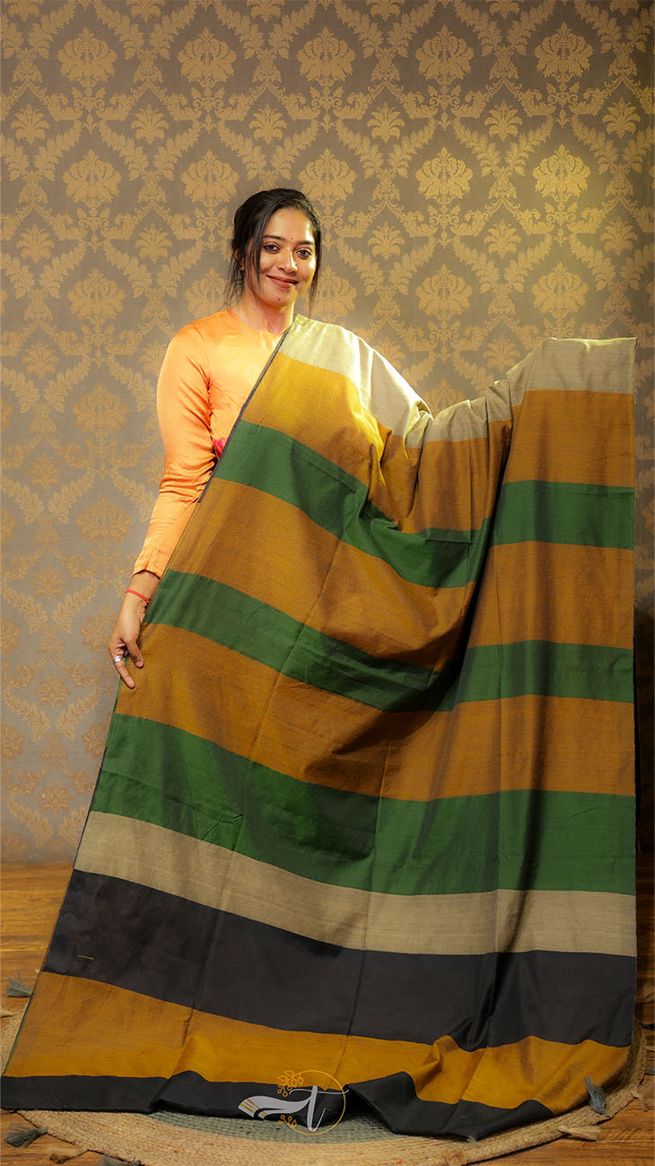 Woman holding a multicolored striped fabric against a patterned wall.