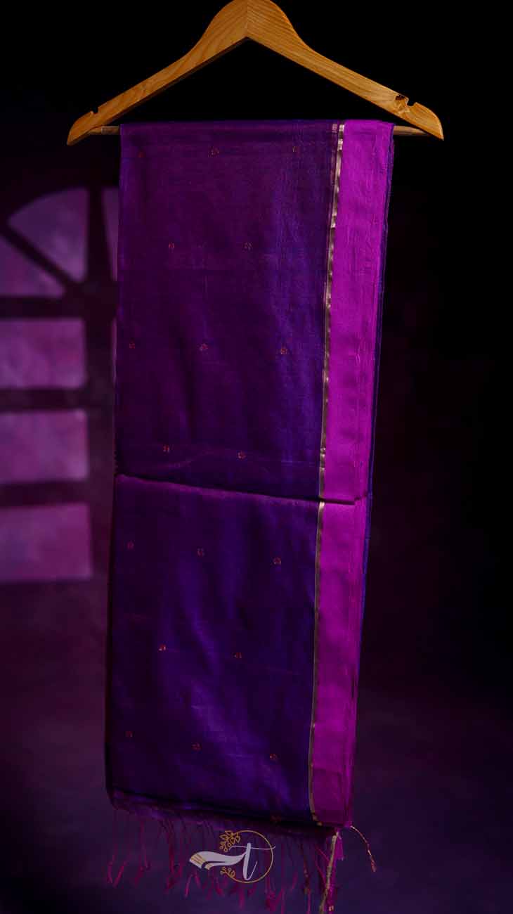 Purple fabric with gold trim on a hanger against a dark background