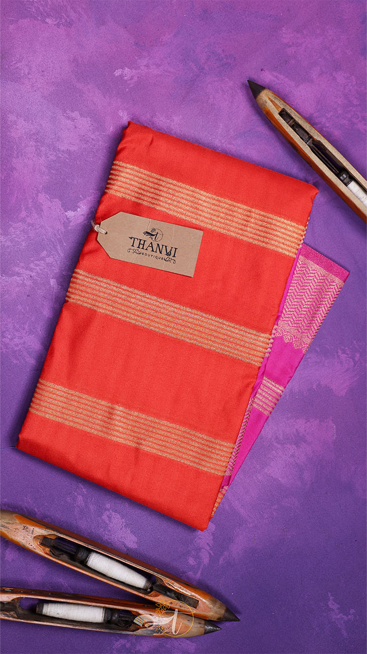 Red saree with gold stripes on a purple background, featuring a THANVI tag.