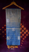 Blue fabric with white patterns on a hanger against a dark background