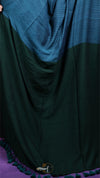 Green fabric draped over a purple surface with a brand logo.