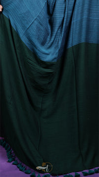 Green fabric draped over a purple surface with a brand logo.