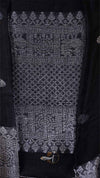 Close-up of a patterned fabric with intricate designs on a dark background