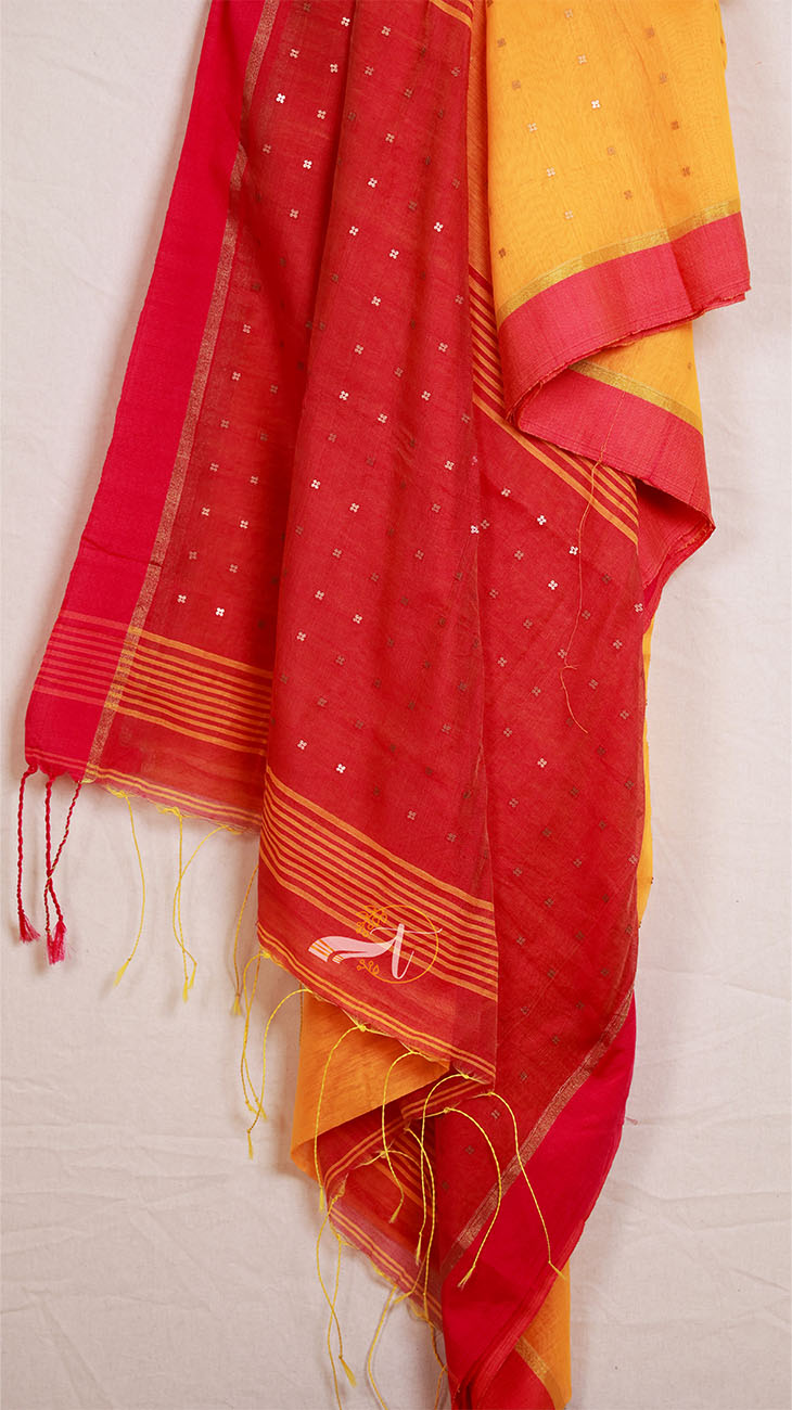 Red and yellow saree with white patterns on a light gray background