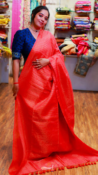 Woman wearing a red saree with a blue blouse in a store setting