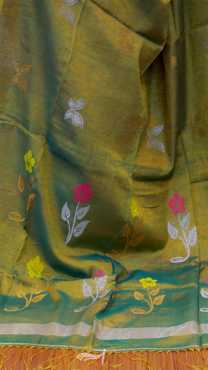 Green fabric with floral embroidery on a colorful background