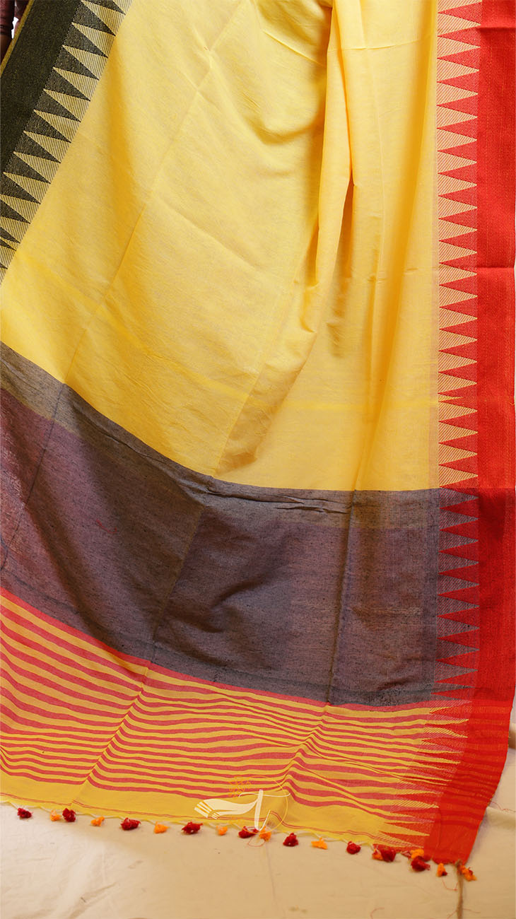 Yellow saree with red and black border on a plain background