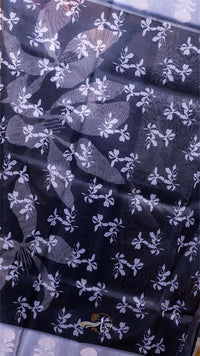 Black fabric with white floral pattern on a blue background