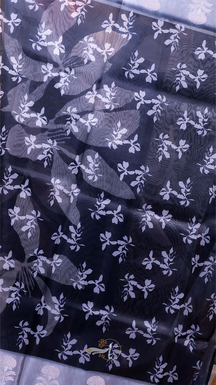 Black fabric with white floral pattern on a blue background