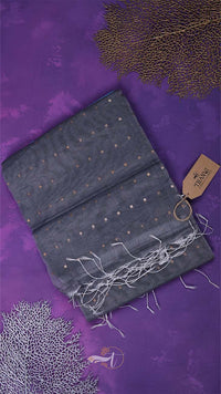 Folded dark gray scarf with gold accents on a purple background