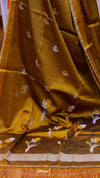 Brown fabric with white floral patterns, possibly a sari or a similar garment.