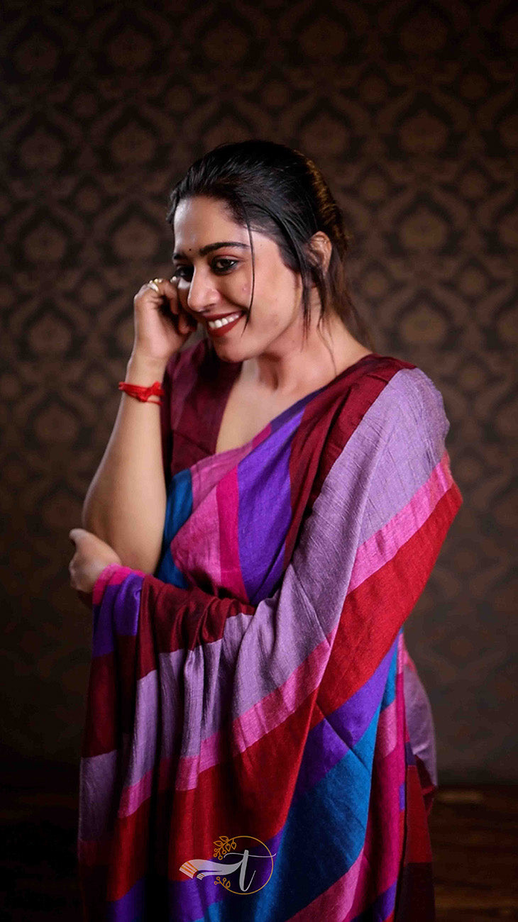 Woman wearing a colorful saree with a patterned background