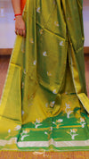 Green saree with white floral patterns on a wooden floor background