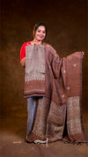 Woman holding a large brown and beige patterned fabric against a brown background
