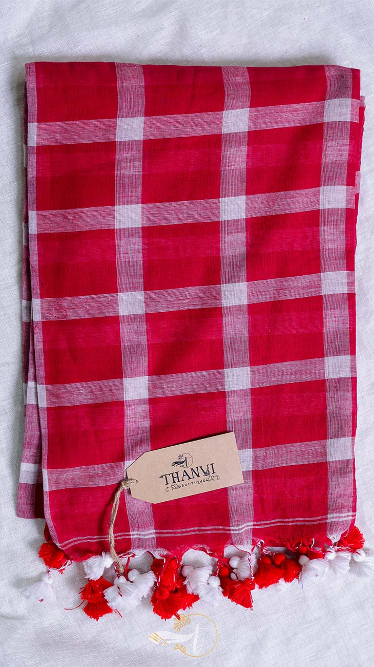 Red and white checkered towel with tassels and a brand tag on a light background