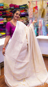 Woman holding a white saree in a colorful fabric store