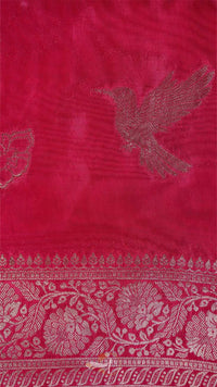 Red fabric with intricate white patterns and a bird design.