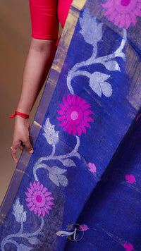 Blue fabric with pink floral patterns held by a person wearing a red sleeve.