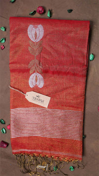 Red scarf with white floral design and fringes on a brown background