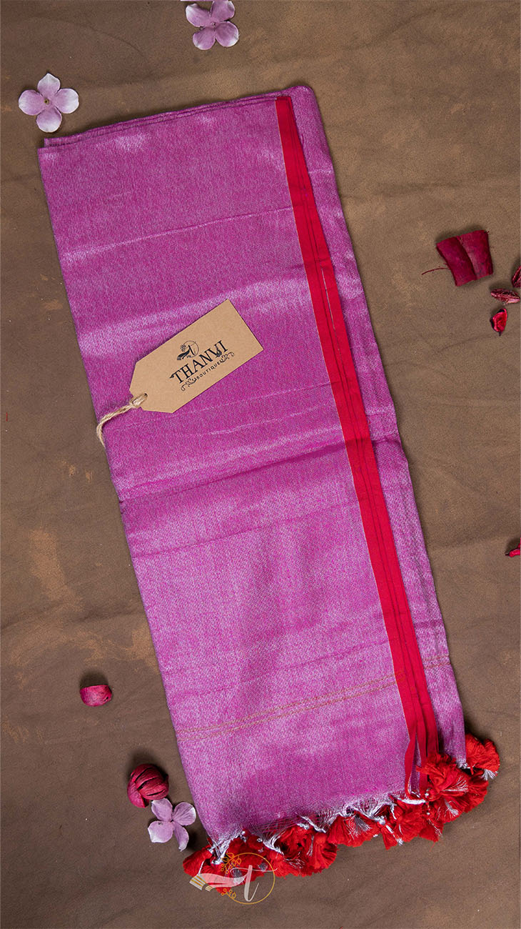 Pink saree with red border and 'Teami' tag on a brown background