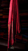 Red fabric with gold accents hanging against a dark background