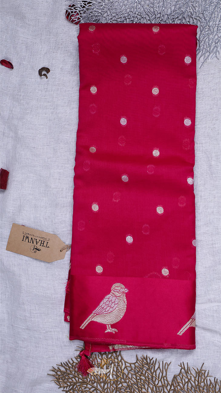 Red fabric with white polka dots and bird design on a textured surface