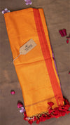 Yellow saree with red border and floral decorations on a brown background