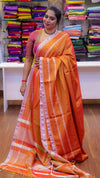 Woman wearing an orange saree with a striped pattern in a store setting.