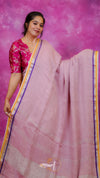 Woman wearing a pink saree with a purple background