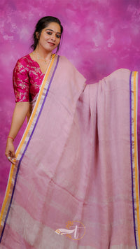 Woman wearing a pink saree with a purple background