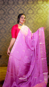 Woman wearing a pink saree with a patterned background