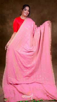 Woman wearing a pink saree with a brown background