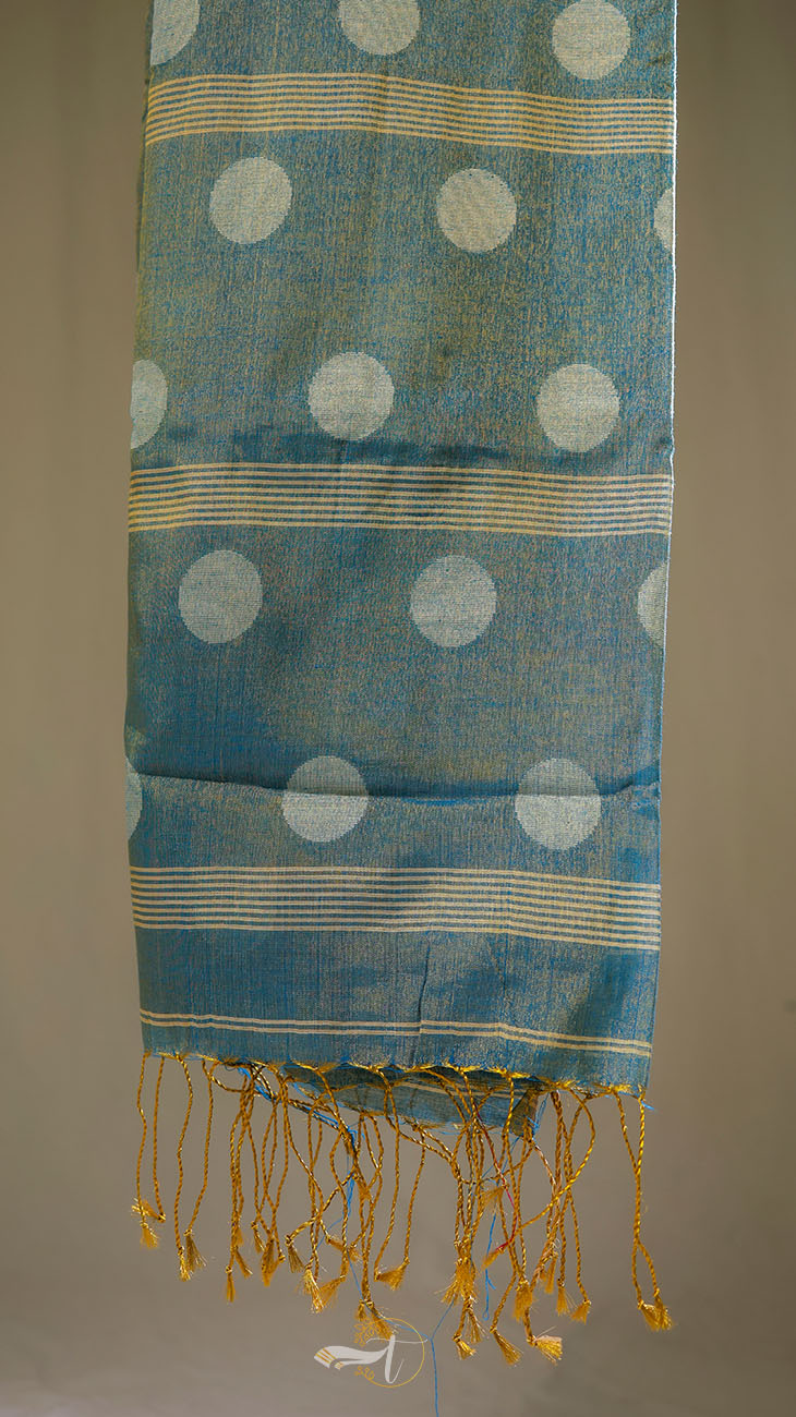 Blue fabric with white polka dots and yellow fringes on a gray background