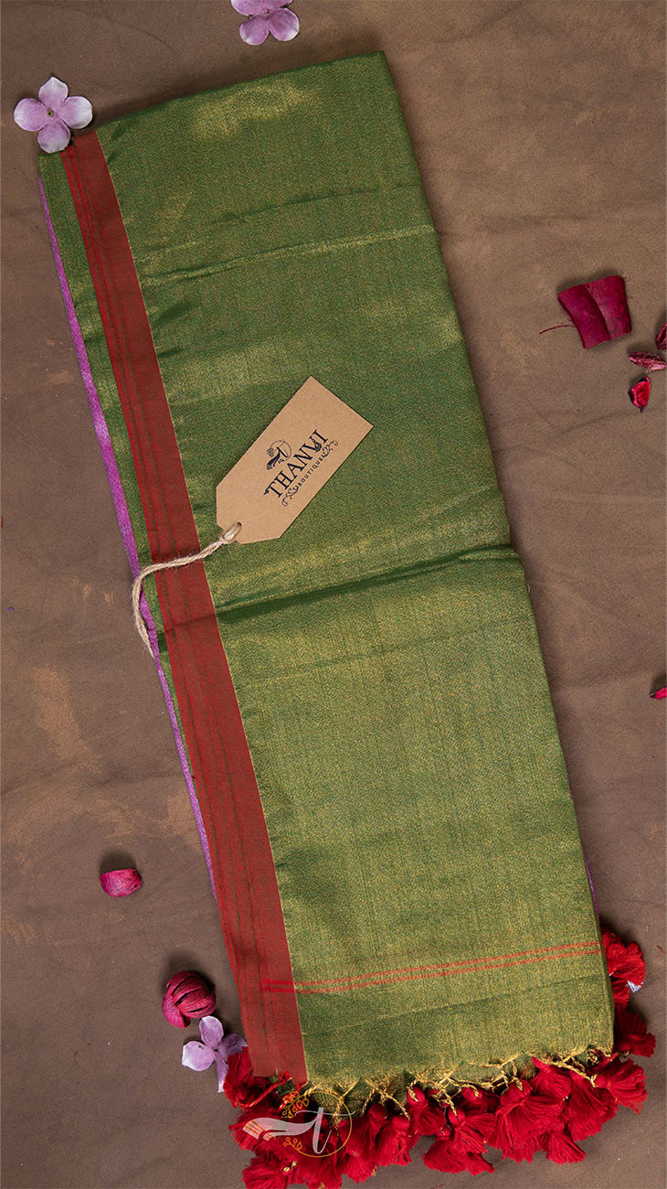 Green fabric with red border and decorative elements on a brown background